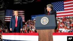 Presiden Donald Trump mendengarkan Sean Hannity dari Fox News berbicara dalam sebuah acara di Show Me Center di Cape Girardeau, 5 November 2018. (Foto: AP)
