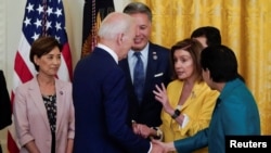 拜登总统在签署了成立研究美国亚太裔历史文化博物馆的法案后与众议院议长佩洛西等议员握手。(2022年6月13日)