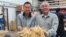 Will Hsu, left, and father Paul Hsu check out some ginseng at their processing center in north-central Wisconsin. (C. Guensburg/VOA)