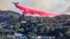 Sebuah tanker udara menjatuhkan bahan kimia anti api di Palisades Fire, salah satu kebakaran beruntun yang melanda Los Angeles County, seperti terlihat dari Woodland Hills, kawasan Los Angeles, California, AS, 11 Januari 2025. (Foto: Ringo Chiu/Reuters)