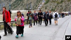 FILE - People cross the Georgia-Russia border at Verkhny Lars, Georgia, Sept. 28, 2022. The Kremlin's announcement of a partial mobilization had sent waves of panic throughout the country. Flights abroad sold out and long lines formed at border crossings.