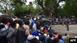 Les soldats de la Force de défense zimbabwéenne empêchent les manifestants d'accéder à la Maison de l'Etat à Harare, 18 novembre 2017.