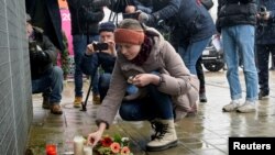 Ljudi ostavljaju cveće ispred zgrade u kojoj se nalazio centar Jehovinih svedoka u Hamburgu, 10. marta 2023. 