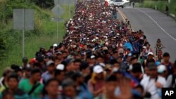 Migrants, part of a caravan traveling from Central America toward the United States, walk on a road that links Ciudad Hidalgo with Tapachula, Mexico, Nov. 2, 2018.