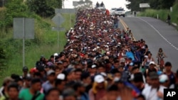 Migrants, part of a caravan traveling from Central America toward the United States, walk on a road that links Ciudad Hidalgo with Tapachula, Mexico, Nov. 2, 2018.