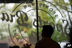 The Sports Bra founder and CEO Jenny Nguyen looks towards the door as a customer enters at the sports bar on Thursday, April 25, 2024, in Portland, Ore. (AP Photo/Jenny Kane)
