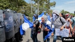 A demonstrator shouts slogans to riot police during a protest against Nicaraguan President Daniel Ortega's government in Managua, Nicaragua September 23, 2018. 