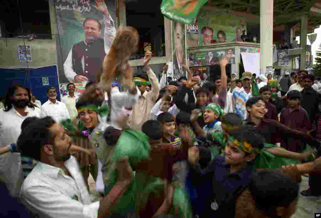 Supporters of Pakistan&#39;s former Prime Minister Nawaz Sharif celebrate after initial results from parliamentary elections put his party in the lead, Islamabad, May 12, 2013. 