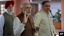 FILE - Indian Prime Minister Narendra Modi, center, arrives for a Bharatiya Janata Party (BJP) parliamentary party meeting in New Delhi, India, Nov. 29, 2016. Modi has been facing public pressure to overhaul political financing following his drastic move last November of banning high denomination notes to flush out illicit cash.