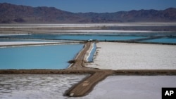 FILE - A truck is parked between brine evaporation ponds at Albemarle Corp.'s Silver Peak lithium facility, Oct. 6, 2022, in Silver Peak, Nev. (AP Photo/John Locher, File)