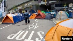 A pro-democracy protester walks in an occupied area, outside the government headquarters in Hong Kong, Nov. 13, 2014.