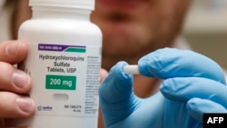 Seorang karyawan apotek menunjukkan botol dan pil hidroksiklorokuin di Provo, Utah, 20 Mei 2020. (Foto: AFP)