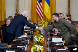 Presiden Joe Biden berjabat tangan dengan Presiden Ukraina Volodymyr Zelenskyy di Ruang Timur Gedung Putih, Kamis, 21 September 2023, di Washington. (Foto: AP/Evan Vucci)