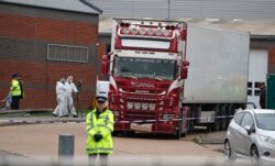 FILE - Police forensics officers attend the scene after a truck was found to contain the bodies of 39 refugees, in Thurrock, South England, Oct. 23, 2019.