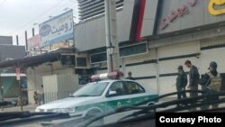 In this photo taken by a Baneh resident, Iranian security forces, including an IRGC officer armed with an Uzi, far right, stage a show of force in Baneh, Iran, as a general strike continues, May 2, 2018. 