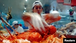 资料照：澳大利亚悉尼海鲜市场的一名商贩在展示他烹饪的龙虾。