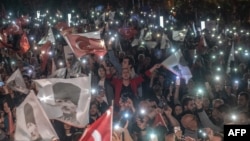Para pendukung Wali Kota Istanbul Ekrem Imamoglu melambaikan bendera dalam unjuk ras memprotes pemungutan suara ulang di Istanbul, 6 Mei 2019.
