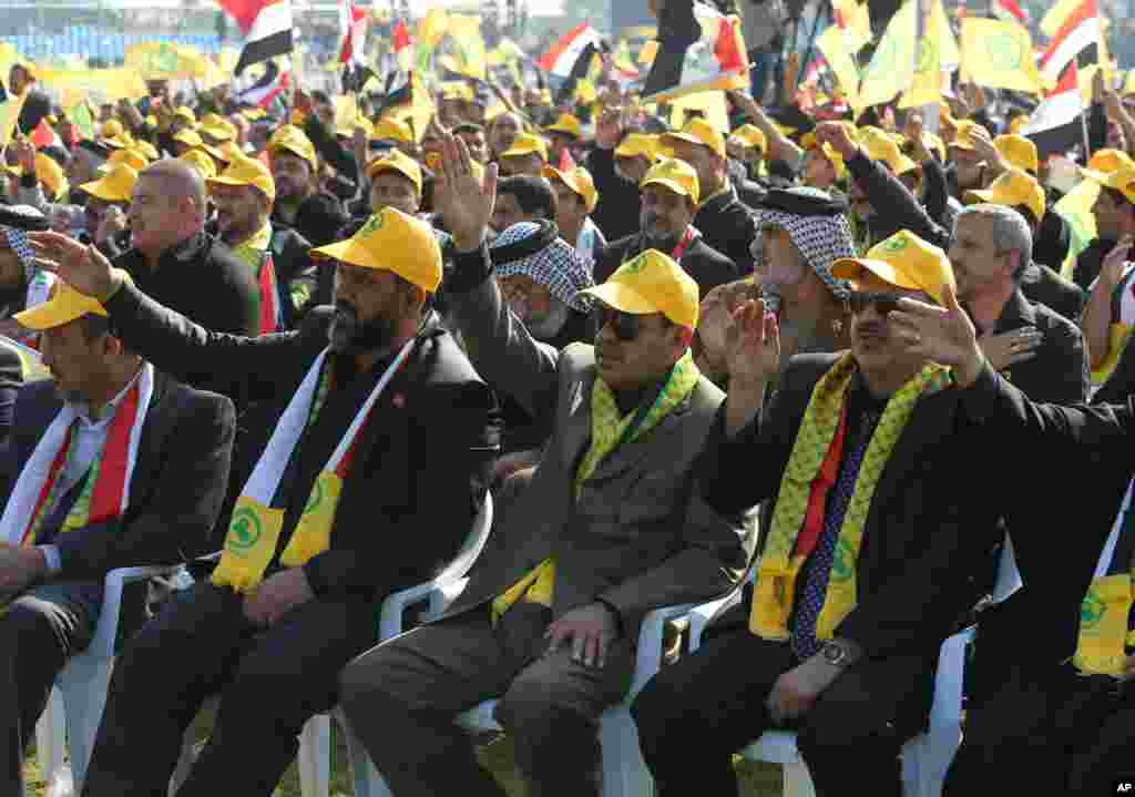 Para pendukung partai Syiah terbesar di Irak, Dewan Tertinggi Islami Irak, mendengarkan pemimpin mereka Ammar al-Hakim dalam sebuah pawai yang menandai perayaan Ashura di Baghdad (13/11). (AP/Karim Kadim)