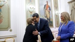 U.N. High Commissioner for Human Rights Michelle Bachelet, left, is greeted by Venezuela's President Nicolas Maduro, as first lady Cilia Flores looks on, at Miraflores Presidential Palace, in Caracas, Venezuela, Friday, June 21, 2019.