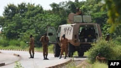 FILE - Burkinabe soldiers patrol near the Presidential Security Regiment military barracks in Ouagadougou, Sept. 29, 2015. Dozens of people have been killed in attacks by armed groups in Burkina Faso in May 2021.