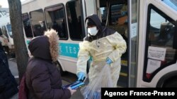 Seorang petugas membagikan alat tes COVID-19 di wilayah Bensonhurst, Brooklyn, Kota New York City, pada 23 Desember 2021. (Foto: AFP/Bryan R. Smith)