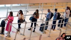 Putnici čekaju na u redu pred ukrcavanje na avion u Lav fild aerodromu u Dalasu, 28. maja 2021.