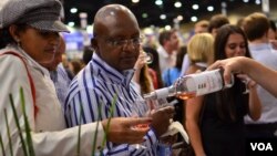 A couple at the WineX Wine Festival in Sandton samples the red wine from Leopard's Leap, a winery on the Western Cape of South Africa, October 2012. (VOA/Peter Cox) 