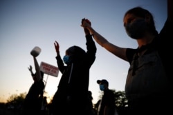 A demonstrator displays a "Black Lives Matter" sign May 28, 2020, in St. Paul, Minn. Protests over the death of George Floyd, a black man who died in police custody, broke out in the Minneapolis area for a third straight night.