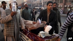 People care for a person injured in a blast in Peshawar, Pakistan, December 3, 2012.