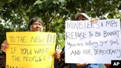 Sri Lankan civil rights activists hold placards during a demonstration outside the official residence of ousted Prime Minister Ranil Wickremesinghe in Colombo, Sri Lanka, Nov 4, 2018. 