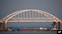 FILE - A Russian tanker under the Kerch bridge blocks the passage to the Kerch Strait near Kerch, Russia-annexed Crimea, Nov. 25, 2018. A Russian oil tanker carrying thousands of tons of oil products split apart during a heavy storm, Dec. 15, 2024.