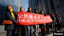 Para pendukung Xu Zhiyong, salah satu aktivis hak asasi manusia di China yang paling terkemuka, meneriakkan slogan-slogan di luar gedung pengadilan di Beijing (22/1). (Reuters/Kim Kyung-Hoon)