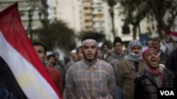 Demonstran anti-pemerintah meneriakkan slogan-slogan di dekat gedung parlemen Mesir, Kamis (10/2).