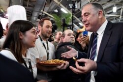French Agriculture Minister Didier Guillaume, right, visits the 57th International Agriculture Fair at the Porte de Versailles exhibition center in Paris on Feb. 22, 2020.