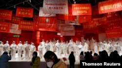 Visitors attend an exhibition on the fight against the coronavirus disease (COVID-19) outbreak, at Wuhan Parlor Convention Center that previously served as a makeshift hospital for COVID-19 patients in Wuhan, Hubei province, China, Dec. 31, 2020.