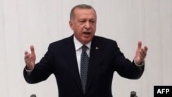 Turkish President Recep Tayyip Erdogan gestures as he delivers a speech during the opening of the third legislative session of the Turkish parliament’s 27th term, at the Grand National Assembly of Turkey in Ankara, Oct. 1, 2019. Turkish President Recep T