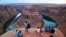 FILE - Visitors view the dramatic bend in the Colorado River at the popular Horseshoe Bend at the Glen Canyon National Recreation Area, in Page, Arizona, Sept. 9, 2011. 