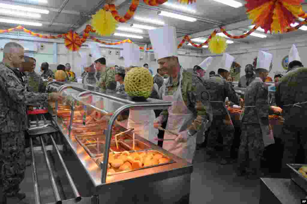 Officers of the Combined Joint Task Force &ndash; Operation Inherent Resolve, the U.S-led effort against the Islamic State group, serve their soldiers Thanksgiving Day dinner in a dining facility at Camp Arifjan, Kuwait, Nov. 23, 2017.