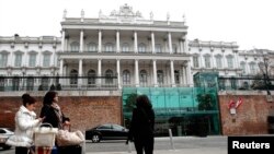 People pass by Palais Coburg hotel where nuclear talks are taking place in Vienna, Feb. 19, 2014. 