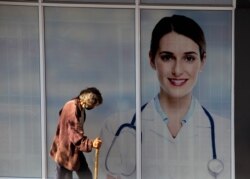 FILE - A man passes doctors consulting rooms in Johannesburg, April 16, 2021.