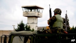FILE - Soldiers patrol outside Cieneguillas state prison in Mexico, May 16, 2009, where an armed gang had freed more than 50 inmates. At least 16 inmates were killed in a riot at the prison on Dec. 31, 2019. 