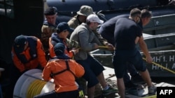 Local and South Korean experts work on a boat during the search for survivors at the site of a boat accident on the Danube river, June 1, 2019, in Budapest. The work has been hampered by high river levels and a strong current after weeks of heavy rain.