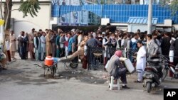 Afghans wait in long lines for hours to try to withdraw money, in front of Bank in Kabul, Afghanistan, Monday, Aug. 30, 2021. The Taliban have limited weekly withdrawals to $200. (AP Photo/Khwaja Tawfiq Sediqi)