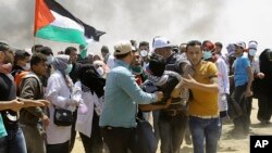 បាតុករ​​ប៉ាឡេស្ទីន​នាំ​យុវជន​ម្នាក់​ដែល​របួស​ចេញ​ពី​កន្លែង​បាតុកម្ម​នៅ​ក្បែរ​របង​ព្រំដែន​អ៊ីស្រាអែល នៅ​ក្នុង​តំបន់ Gaza Strip កាលពី​ថ្ងៃទី១៤ ខែឧសភា ឆ្នាំ២០១៨។