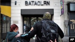 FILE - Relatives pay their respects outside the Bataclan concert hall marking the fifth anniversary of the Nov. 13, 2015, attacks, in Paris, Nov. 13, 2020. 