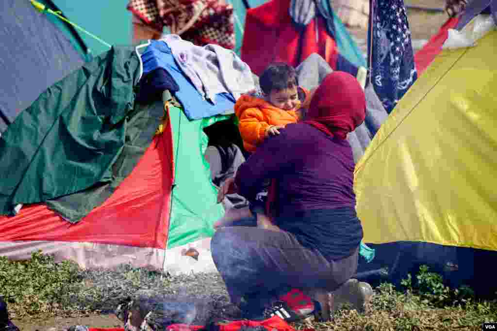 Woman with child at Idomeni refugee camp on the Greece-Macedonia border, March 8, 2016. (Jamie Dettmer for VOA)