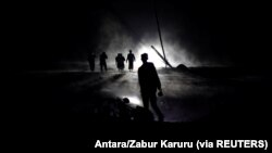 Warga menyusuri jalan yang tertutup abu vulkanik yang dimuntahkan Gunung Semeru di Desa Sumber Wuluh, Lumajang, Jawa Timur, 5 Desember 2021. (Foto: Antara/Zabur Karuru via REUTERS)