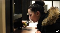 In this September 21, 2015, file photo, Autumn Regimbal blows into a Breathalyzer in the wing of the county jail dedicated to the state's 24/7 Sobriety Program in Sioux Falls, S.D. (AP Photo/Jay Pickthorn, File)