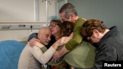 Fernando Simon Marman na Louis Hare, mateka wawili wa Israel wakiungana tena na wapendwa wao kwenye hospitali ya Sheba, Februari 12, 2024. 