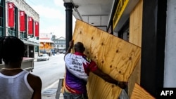 Mkazi afunga dirisha za nyumba yake kabla ya kimbunga Beryl kuwasili mjini Bridgetown, Barbados .Juni, 30, 2024.